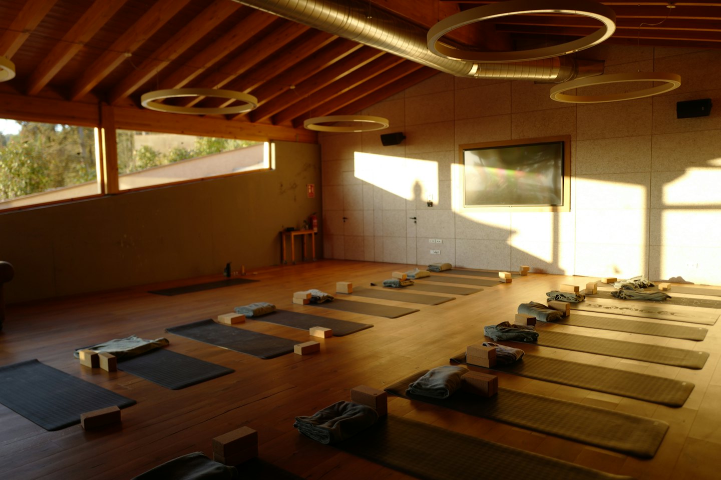 Moderne yogastudio innredet for time med matter og utstyr.